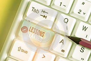 Text sign showing Lessons Learned. Conceptual photo the knowledge or understanding gained by experience White pc keyboard with
