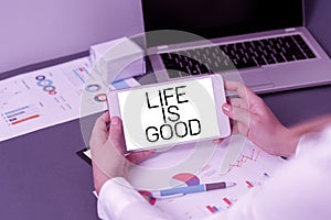 Text sign showing Life Is Good. Word for Obtain everything you want and more have health great job Businesswoman Holding