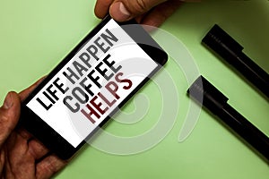 Text sign showing Life Happen Coffee Helps. Conceptual photo Have a hot drink when having problems troubles Man's hand hold iPhon
