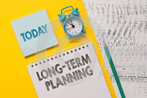 Text sign showing Long Term Planning. Conceptual photo Establish Expected Goals five or more years ahead Spiral notepad