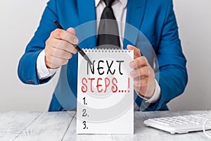 Text sign showing Next Steps. Conceptual photo something you do after you have finished doing first one Man holds empty