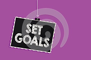 Text sign showing Set Goals. Conceptual photo Defining or achieving something in the future based on plan Hanging blackboard messa