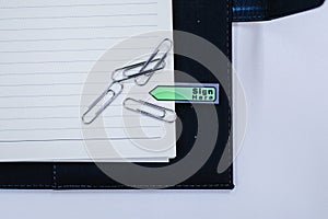 Text sign showing `Sign here` sticker on document on white paper Paper sheets