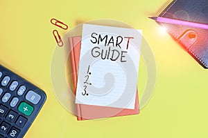Text sign showing Smart Guide. Conceptual photo used to guide the development of measurable goals to attain Pile of