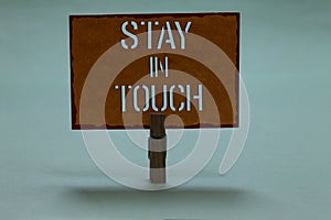 Text sign showing Stay In Touch. Conceptual photo Keep Connected thru Phone Letters Visit Email Social Media Clothespin holding or