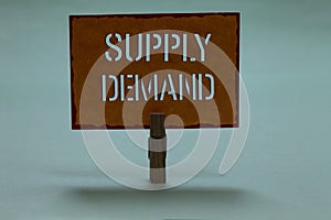 Text sign showing Supply Demand. Conceptual photo Relationship between the amounts available and wanted Clothespin holding orange