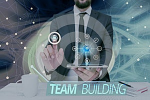Text sign showing Team Building. Conceptual photo Types of activities used to enhance social relations Man holding