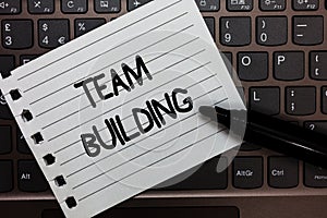 Text sign showing Team Building. Conceptual photo Types of activities used to enhance social relations Notebook piece paper keyboa