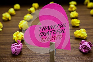 Text sign showing Thankful Grateful Blessed. Conceptual photo Appreciation gratitude good mood attitude Paperclip hold pink heart