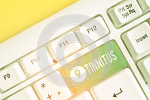 Text sign showing Tinnitus. Conceptual photo A ringing or music and similar sensation of sound in ears White pc keyboard photo