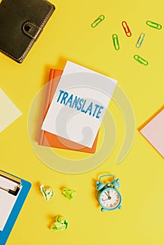 Text sign showing Translate. Conceptual photo Another word with same equivalent meaning of a target language Pile of photo
