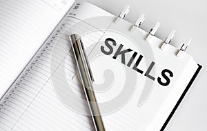 Text SKILLS on the short note texture background with pen