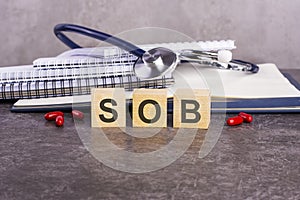 text sob on wooden blocks on a gray background photo