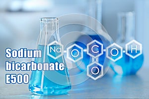 Text Sodium bicarbonate E500 with soda formula and laboratory glassware