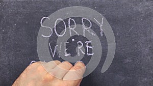 Text sorry we`re closed written with chalk on old blackboard.