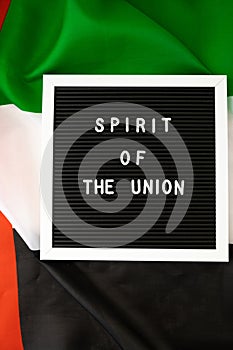 Text SPIRIT OF THE UNION on background flag of UAE. National holiday of United Arab Emirates. Commemoration Day Muslim