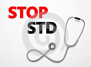 Text STOP STD and stethoscope on white background, top view