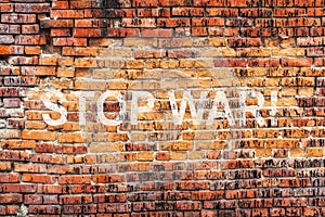 Text STOP WAR on stained old orange brick wall texture background