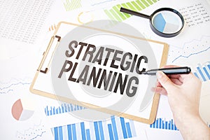 Text Strategic Planning on white paper sheet and marker on businessman hand on the diagram. Business concept