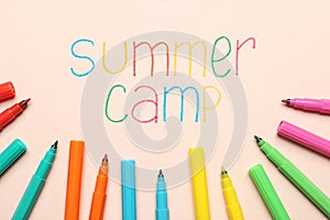 Text SUMMER CAMP and colorful felt tip pens on color background