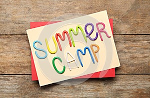 Text SUMMER CAMP made of modelling clay on wooden table