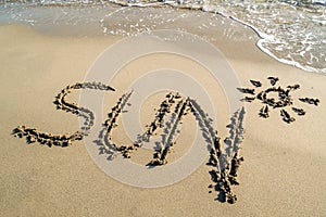 Text sun outline on the wet sandy beach