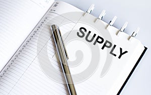 Text SUPPLY on the short note texture background with pen