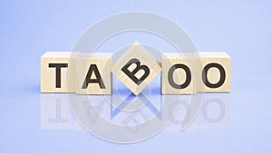 text Taboo - letters by on woodens blocks on pale lilac background, in concept of business and corporation