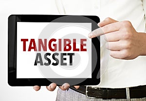 Text tangible asset on tablet display in businessman hands on the white background. Business concept