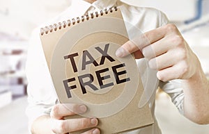 Text tax free on brown paper notepad in businessman hands in office. Business concept