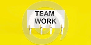 Text TEAM WORK on white short note paper yellow background