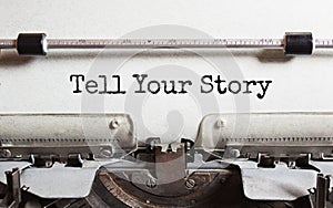 The text TELL YOUR STORY is typed on paper by an antique typewriter. Vintage inscription, retro style, grunge, concept