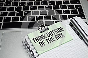 The text Think Outside of the Box on the notepad