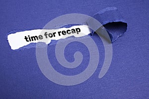 The text TIME FOR RECAP appearing on white paper behind torn