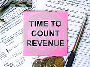 Text Time To Revenue on note paper with the U.S IRS 1040 form,pen and glasses