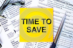 Text Time To Save on note paper with the U.S IRS 1040 form,pen and glasses