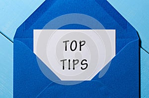 Text TOP TIPS on paper in blue envelope. Business concept