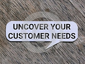 Text UNCOVER YOUR CUSTOMER NEEDS written on bubble speech.