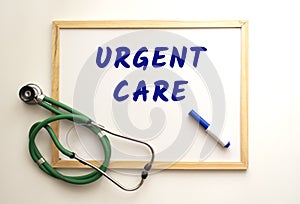 The text URGENT CARE is written on a white office board. Nearby is a stethoscope.