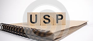 Text usp on the wooden cubes and craft colored notepad on the white background