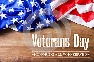 Text VETERANS DAY and USA flag on wooden background, top view