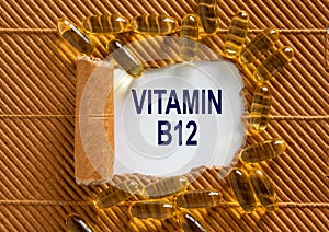 The text `vitamin B12` appearing behind torn brown paper. Yellow pills. Concept. Beautiful background
