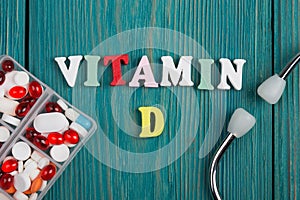 Text & x22;Vitamin D& x22; of colored wooden letters, stethoscope and pills