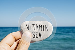 Text vitamin sea in a stone on the beach