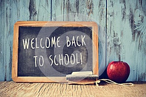 Text welcome back to school written on a chalkboard, cross proce