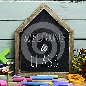 Text welcome to class in a house-shaped chalkboard