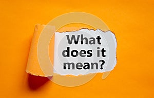 The text `what does it mean` appearing behind torn orange paper. Business concept, copy space