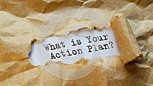 The text WHT IS YOUR ACTION PLAN, appearing behind torn paper. The craft paper is ripped photo