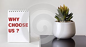 Text Why choose us Question on notepad. Business concept for a list of advantages and disadvantages for product selection