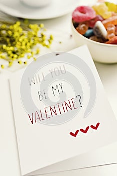 Text will you be my valentine in a postcard